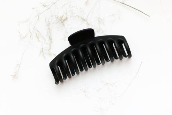 Black plastic claw clip hair accessory laid on a white background.